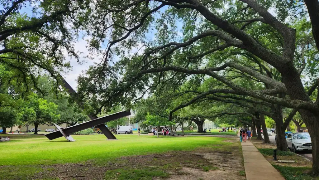 Outside the Menil, towering trees and a quiet neighborhood frame a giant lawn sculpture, creating a peaceful retreat. Credit: Ben Granger