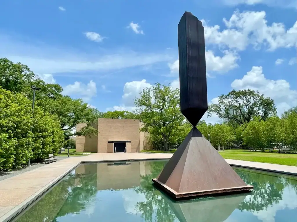 Barnett Newman’s Broken Obelisk rises from a reflecting pool outside the Rothko Chapel, a striking symbol of reflection and resilience. Credit: Hermes Van Amstel