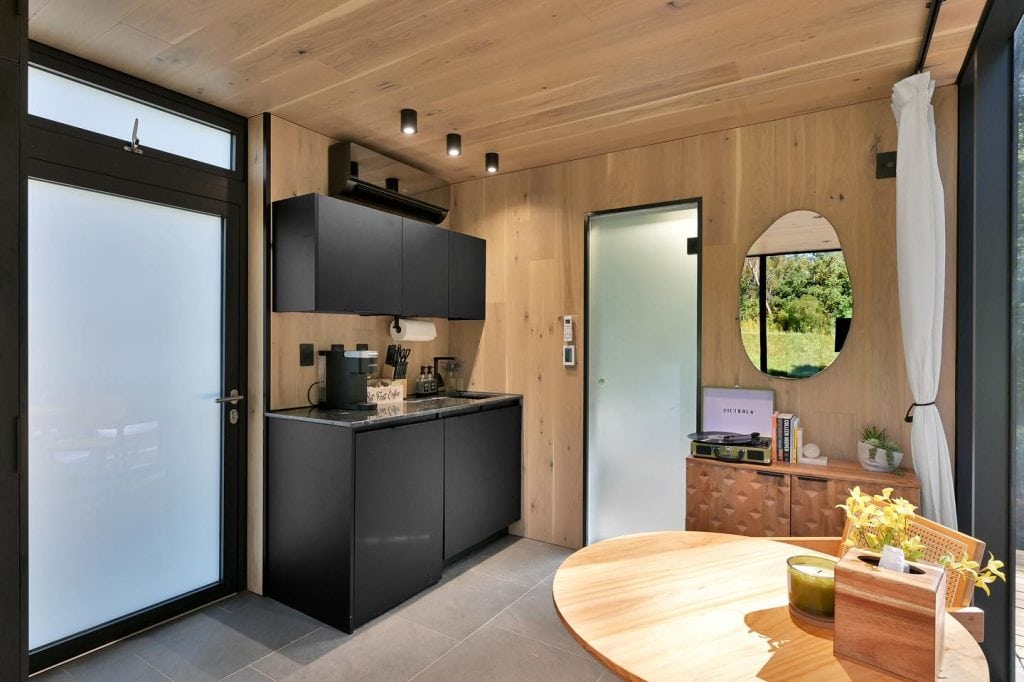 Sleek black kitchenette inside the Mirror House. Fully equipped for prepping simple meals without leaving your sanctuary. Credit: @trakksounds via Instagram