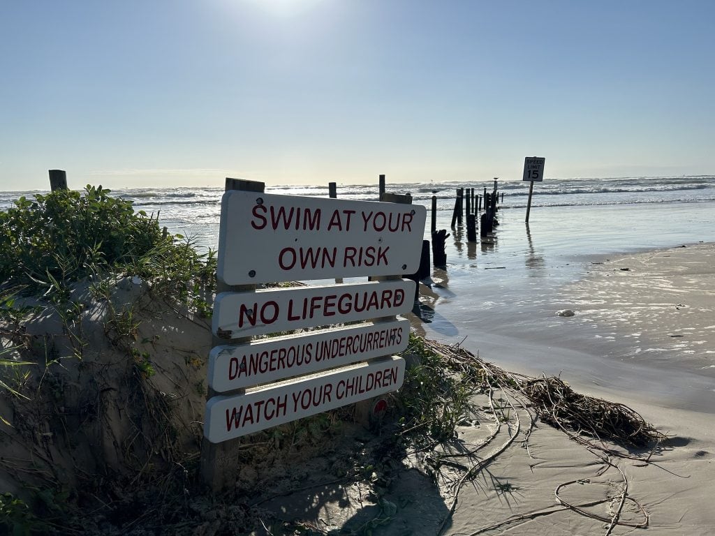 A “Swim at Your Own Risk” sign at Mustang Island State Park—no lifeguards on duty, just you and the Gulf. Credit: @mustangislandstatepark via Instagram