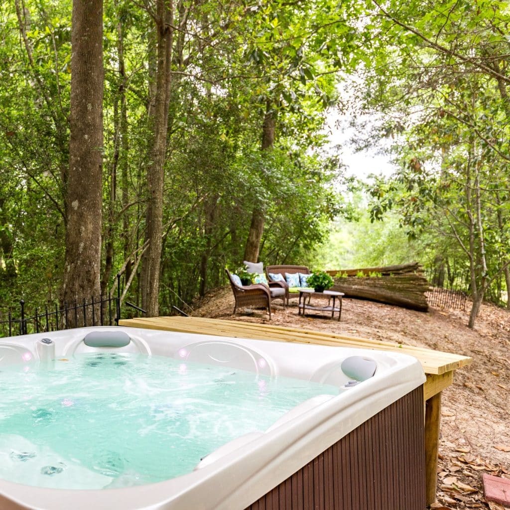 Another outdoor tub setup with lounge seating, offering a peaceful, secluded escape—remote in feel, yet easily accessible. Credit: @naturalistboudoir via Instagram