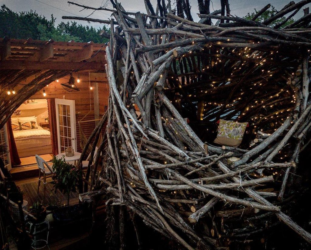 The Nest in all its glory—fairy lights glow around the observatory, while the patio and bedroom come together in one magical, storybook setting. Credit: @skyboxcabins via Instagram