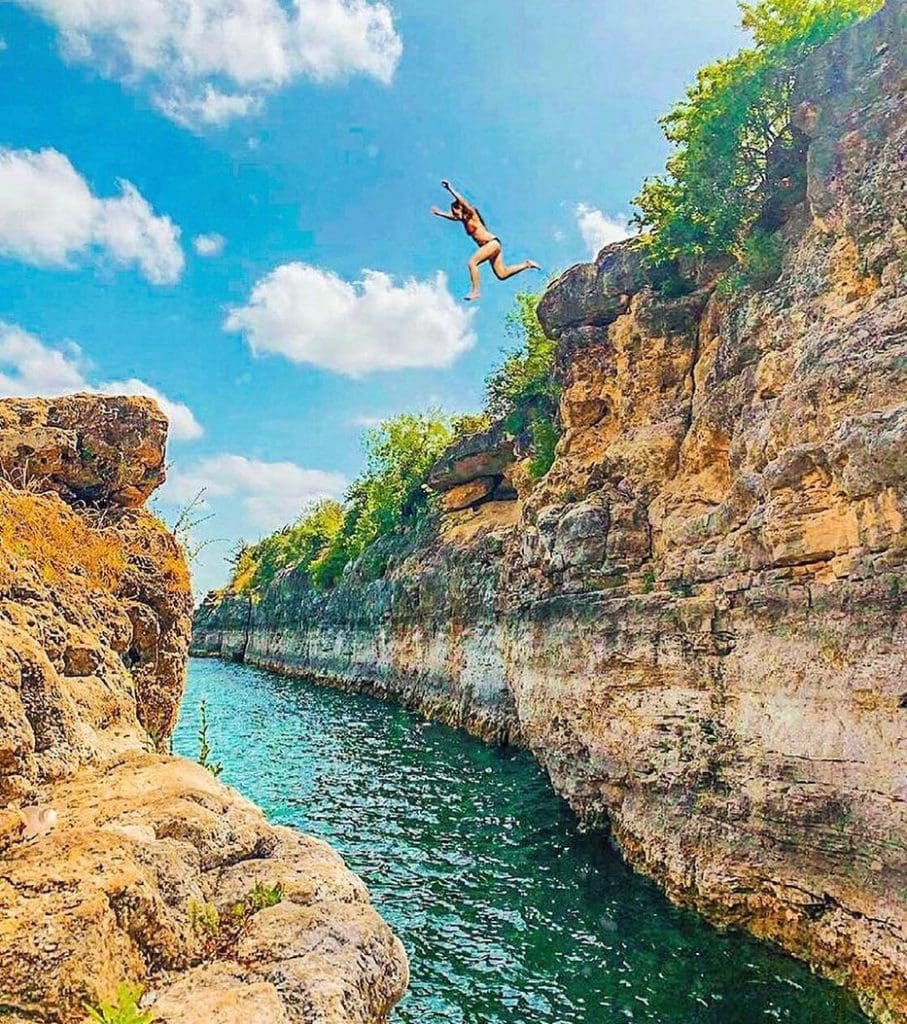Cliff jumping at Pace Bend Park—one of the most adrenaline-packed ways to cool off in Lake Travis. Credit: @explore.texashillcountry via Instagram
