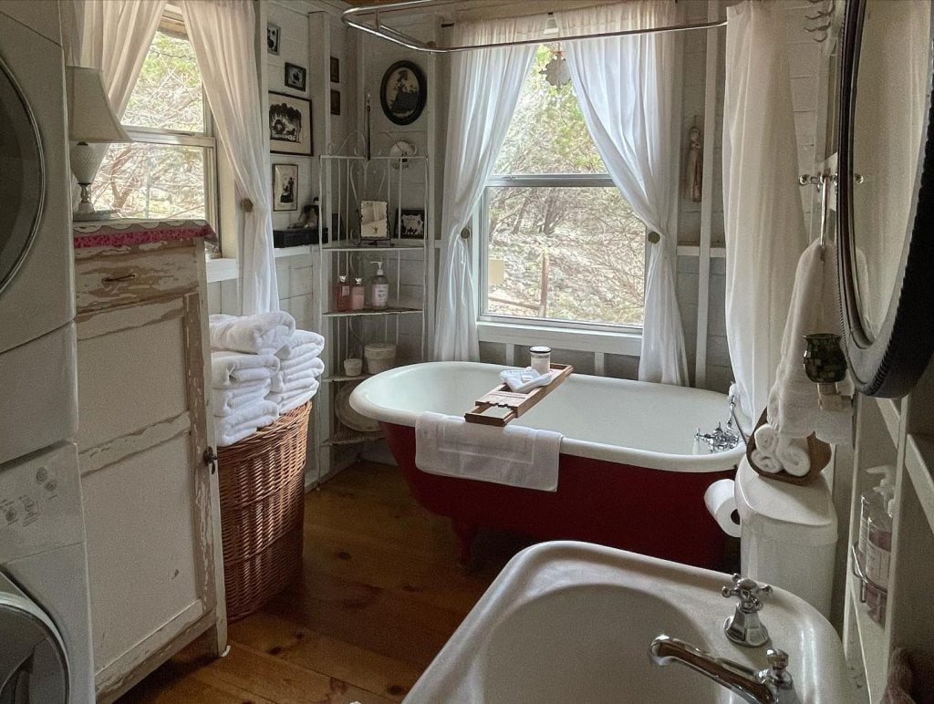 Even the bathroom keeps the old-time charm. An antique-style tub and sink, plus a laundry machine — rustic comfort with everything you need. Credit: @lake1290 via Instagram