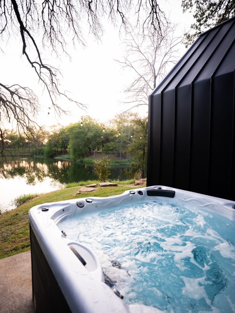 The private outdoor soaking tub at Shadow Bend offers a peaceful nature view—perfect for slowing down and unwinding. Credit: @liveoaklake via Instagram
