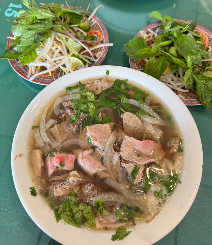 A steaming bowl of pho dac biet comes with plenty of greens on the side, just like in Vietnam. Credit: Anh Nguyen