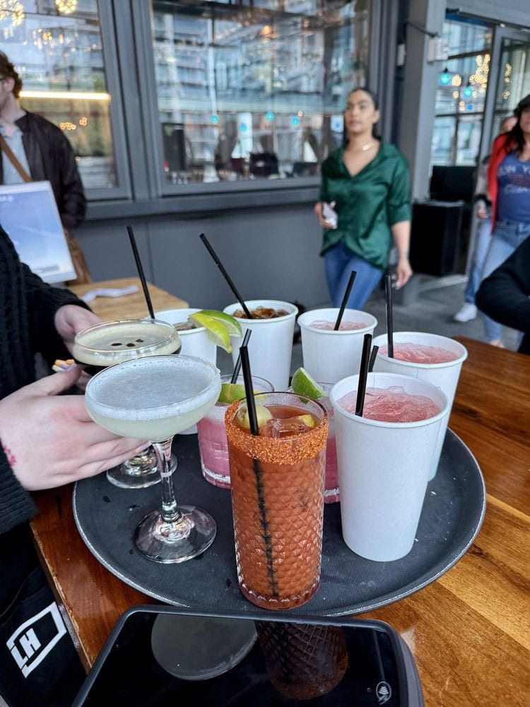 A tray full of margaritas, cocktails, and drinks showcases the vibrant bar scene at Legacy Hall. Credit: Uyen L.