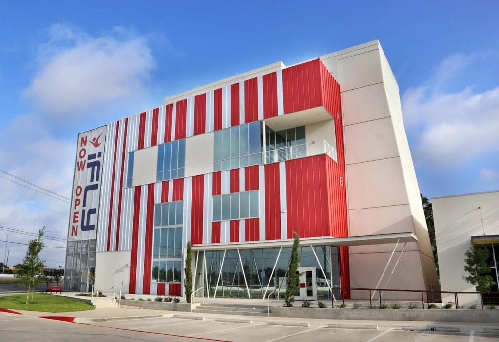 The iFLY indoor skydiving building features modern red‑and‑white architecture with a huge banner that makes it easy to spot. Credit: iFLY Indoor Skydiving - Austin