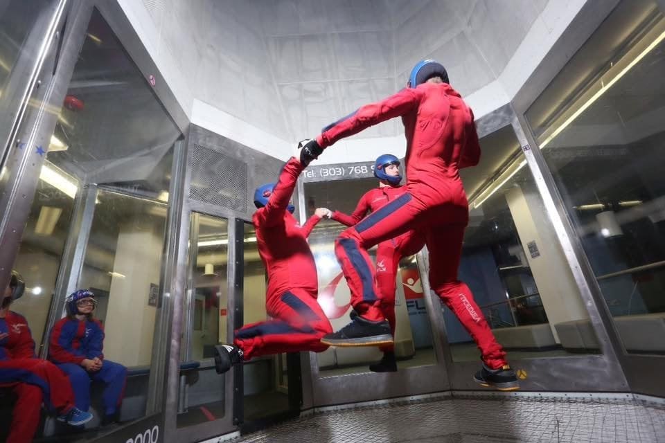 Three people experience the thrill of skydiving together inside the iFLY chamber. Credit: iFLY