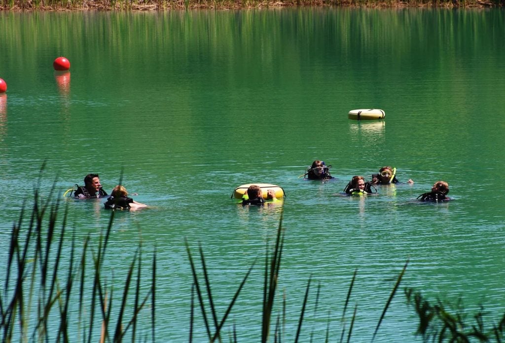 A group of divers gathers at the surface of the lake, preparing for their descent. Credit: Athens Scuba Park