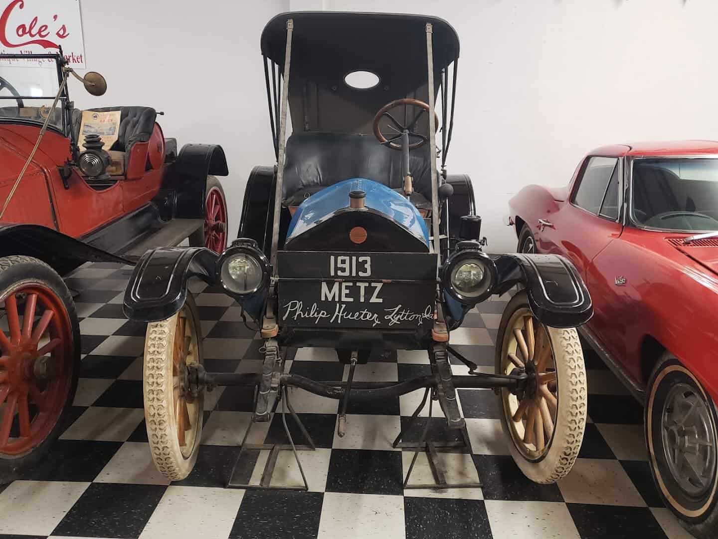 A 1913 Metz antique car on display indoors at Cole's Antique Village in Pearland, Texas