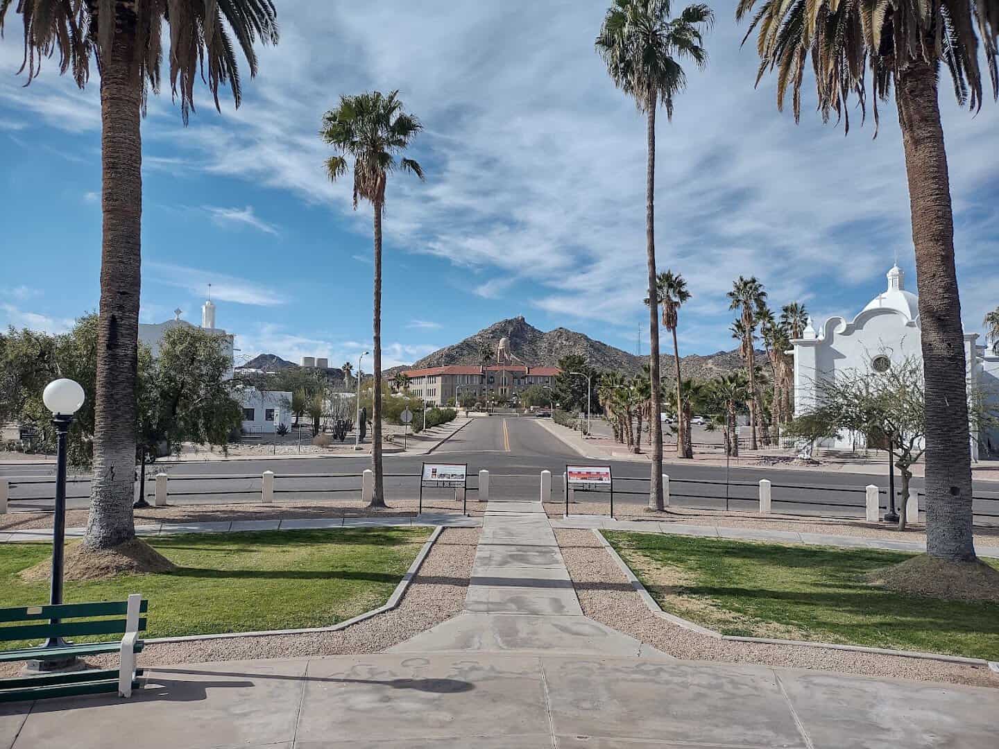 Spanish Colonial Revival plaza with palms and desert peak in Ajo, Arizona
