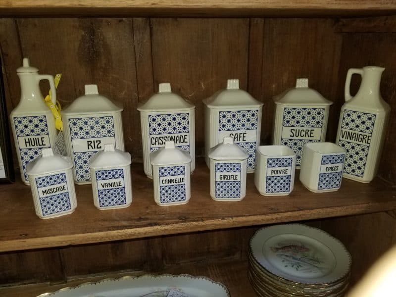 Shelf of white French ceramic kitchen canisters at The Antique Gallery of Houston in Spring, Texas