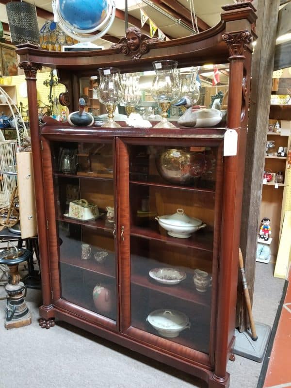 Antique booth with a glass-front curio cabinet at The Antique Gallery of Houston in Spring, Texas
