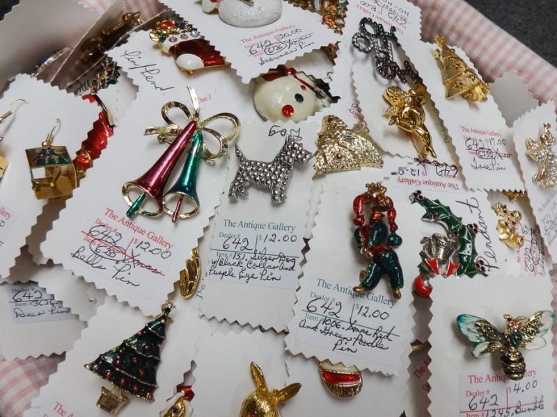 Rack of vintage costume jewelry brooches with price tags at The Antique Gallery of Houston in Spring, Texas