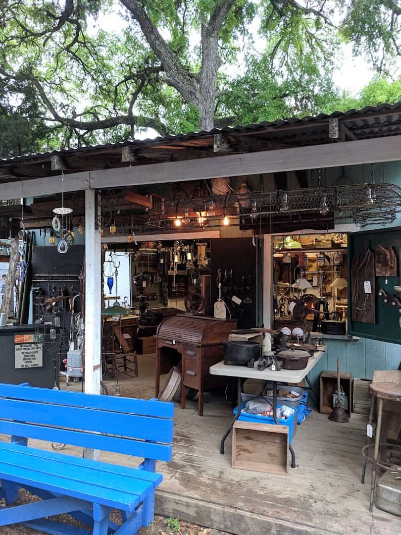 Antiques and vintage goods booth under oak trees at Wimberley Market Days