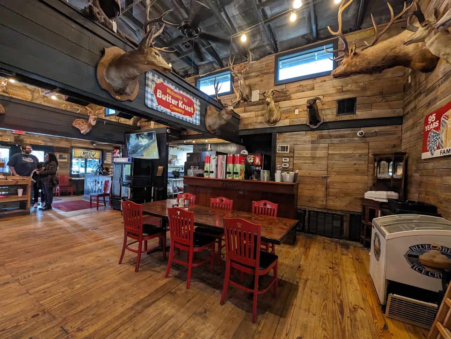 Interior of Richter's Antler Cafe with mounted deer heads, reclaimed wood walls and red chairs in Spring Branch, Texas