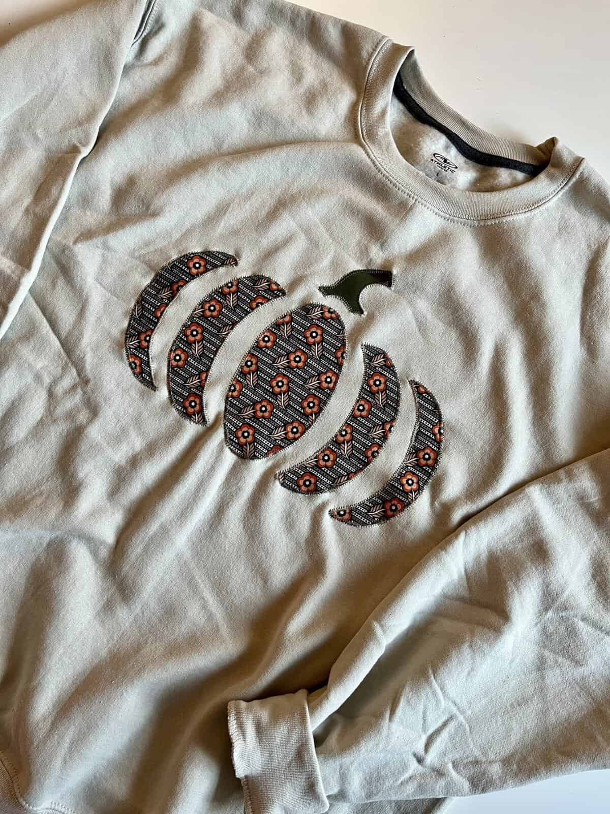 Appliqued pumpkin sweatshirt made with supplies from Pegasus Creative Reuse in Dallas