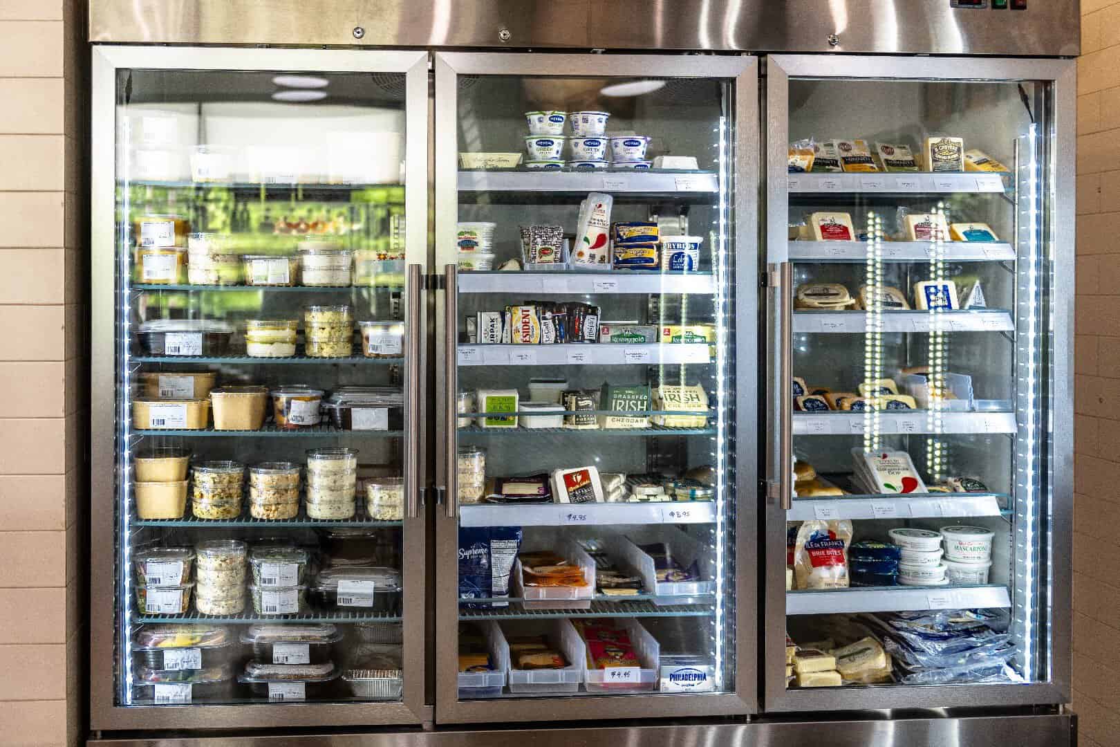 Refrigerated case of cheeses and prepared foods at Ari's Pantry in Dallas