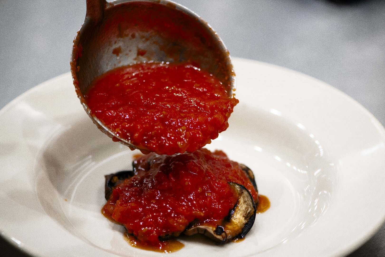 House tomato sauce ladled over grilled eggplant at Ari's Pantry in Dallas