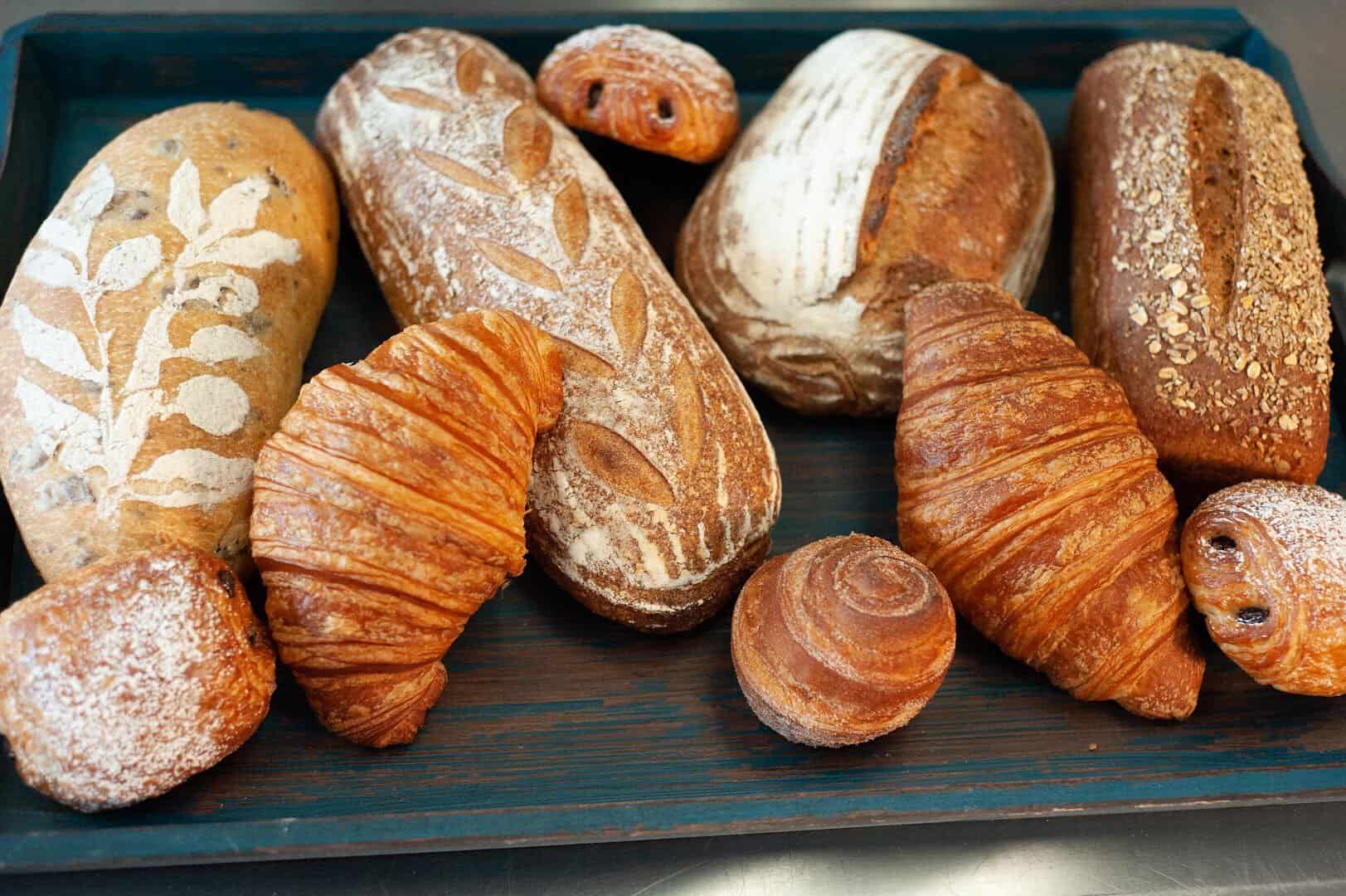Assorted artisan sourdough loaves and croissants at Artisana Bread in Houston, Texas