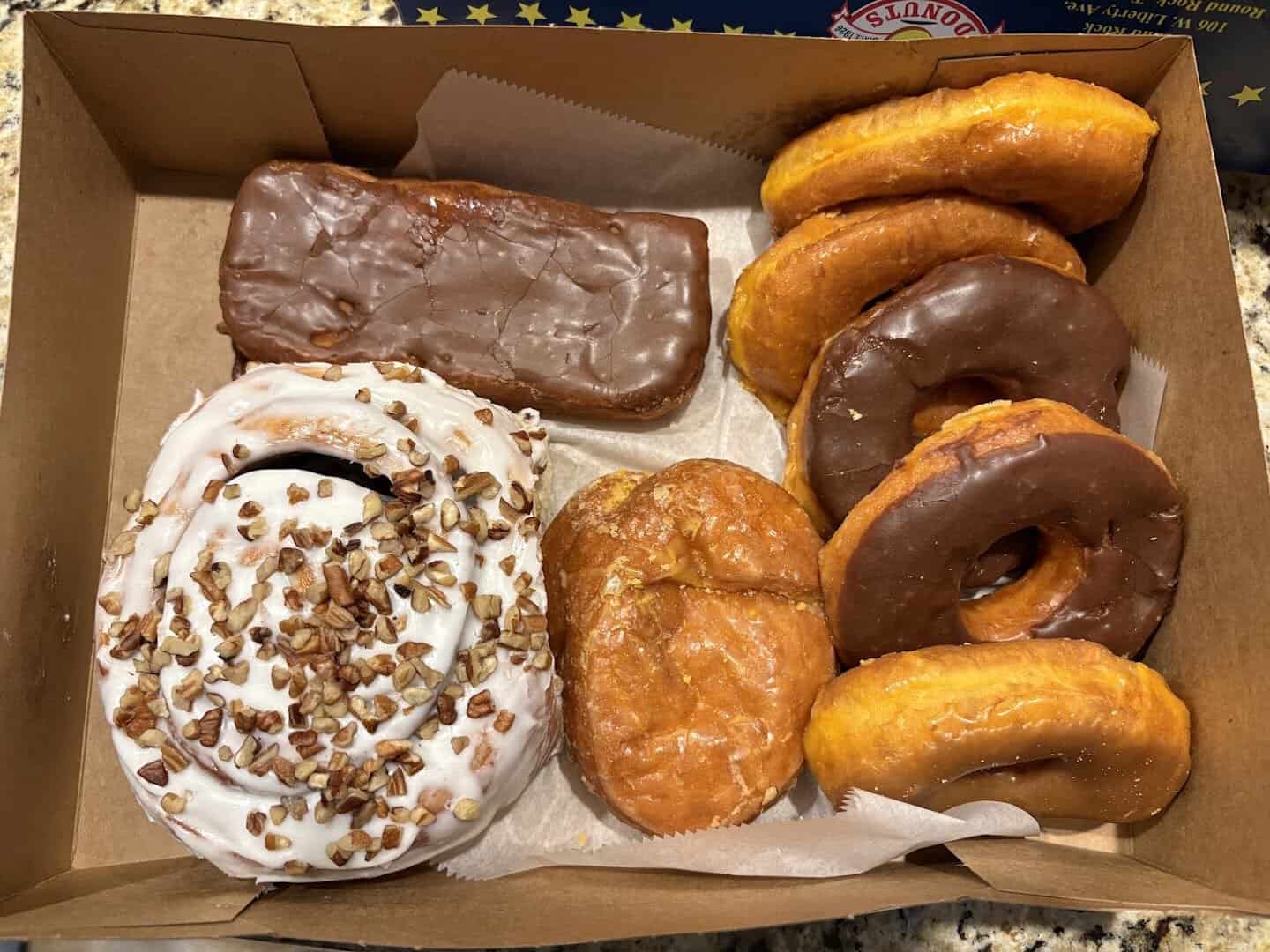 Assorted chocolate and glazed donuts in a box at Round Rock Donuts in Round Rock, Texas
