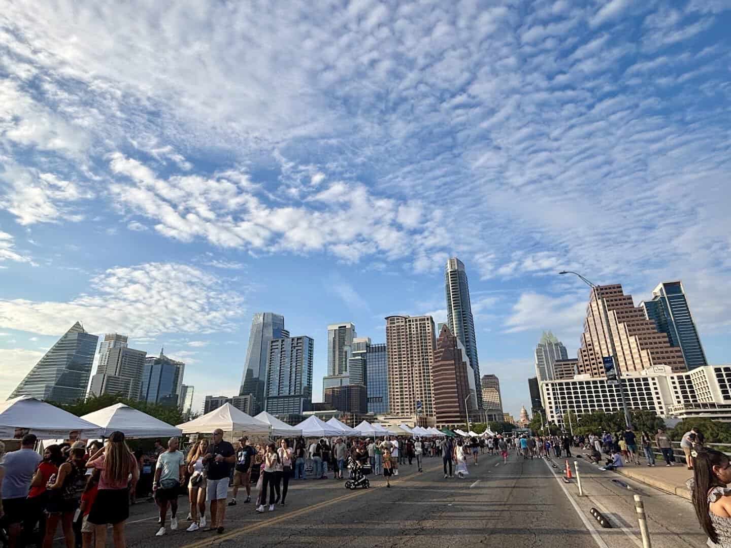 Festival tents filling the closed Congress Avenue Bridge with the Austin skyline beyond