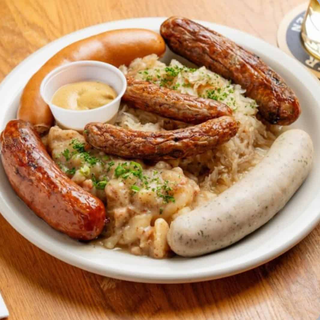 Sausage plate with spaetzle and a pretzel at Bavarian Grill in Plano