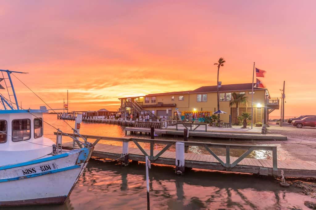 Sunset over the bay with a shrimp boat at Stingaree Restaurant in Crystal Beach