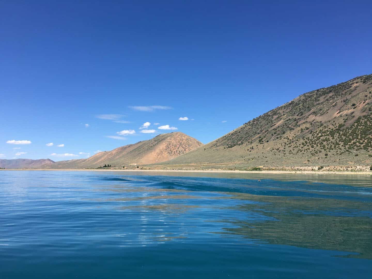 Turquoise water of Bear Lake below sagebrush hills, Utah