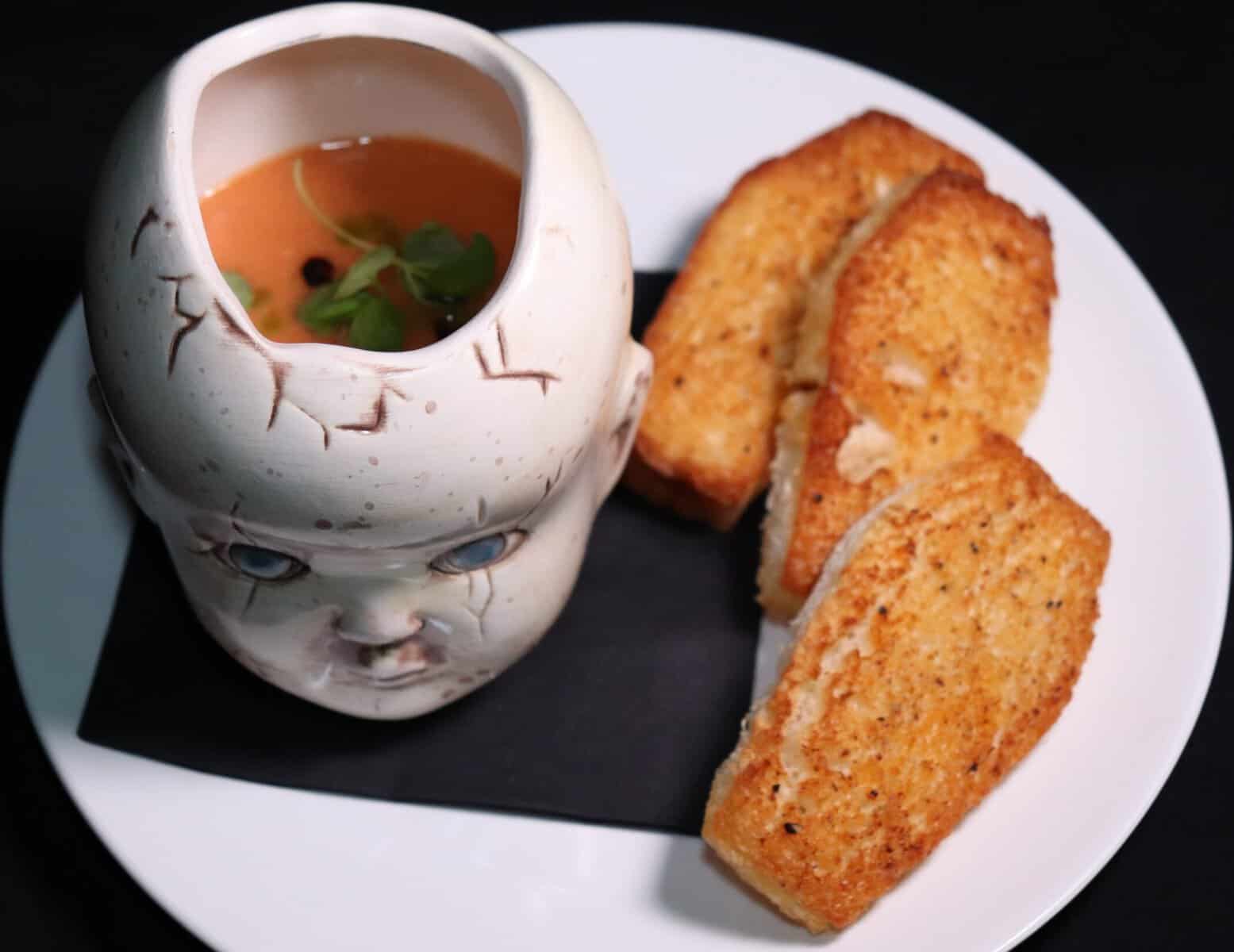 Soup served in a cracked doll-head vessel with toast at Beetle House in New York City