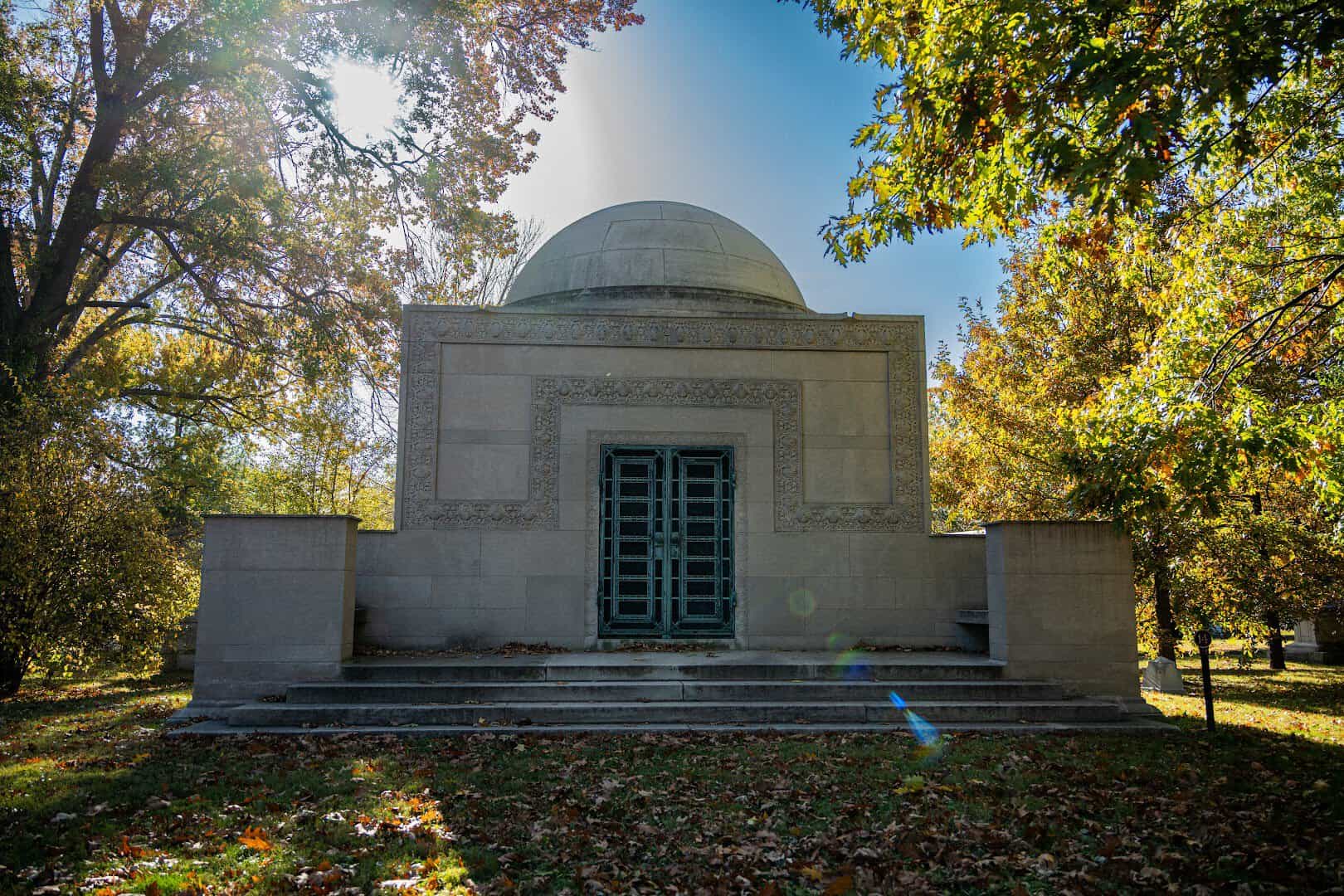 Domed mausoleum surrounded by autumn trees at Bellefontaine Cemetery in St. Louis, Missouri