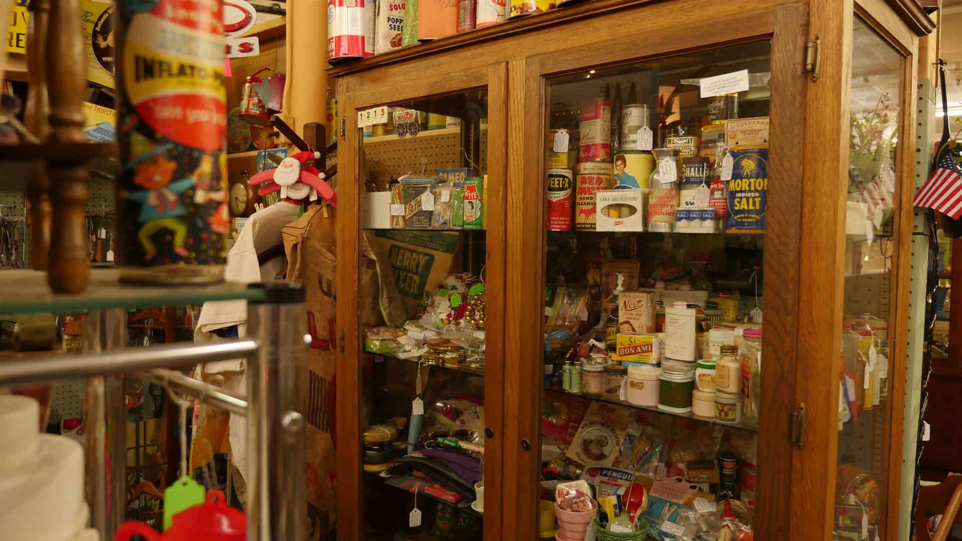 Wide aisle lined with glass display cases at Benbrook Antique Mall in Benbrook, Texas