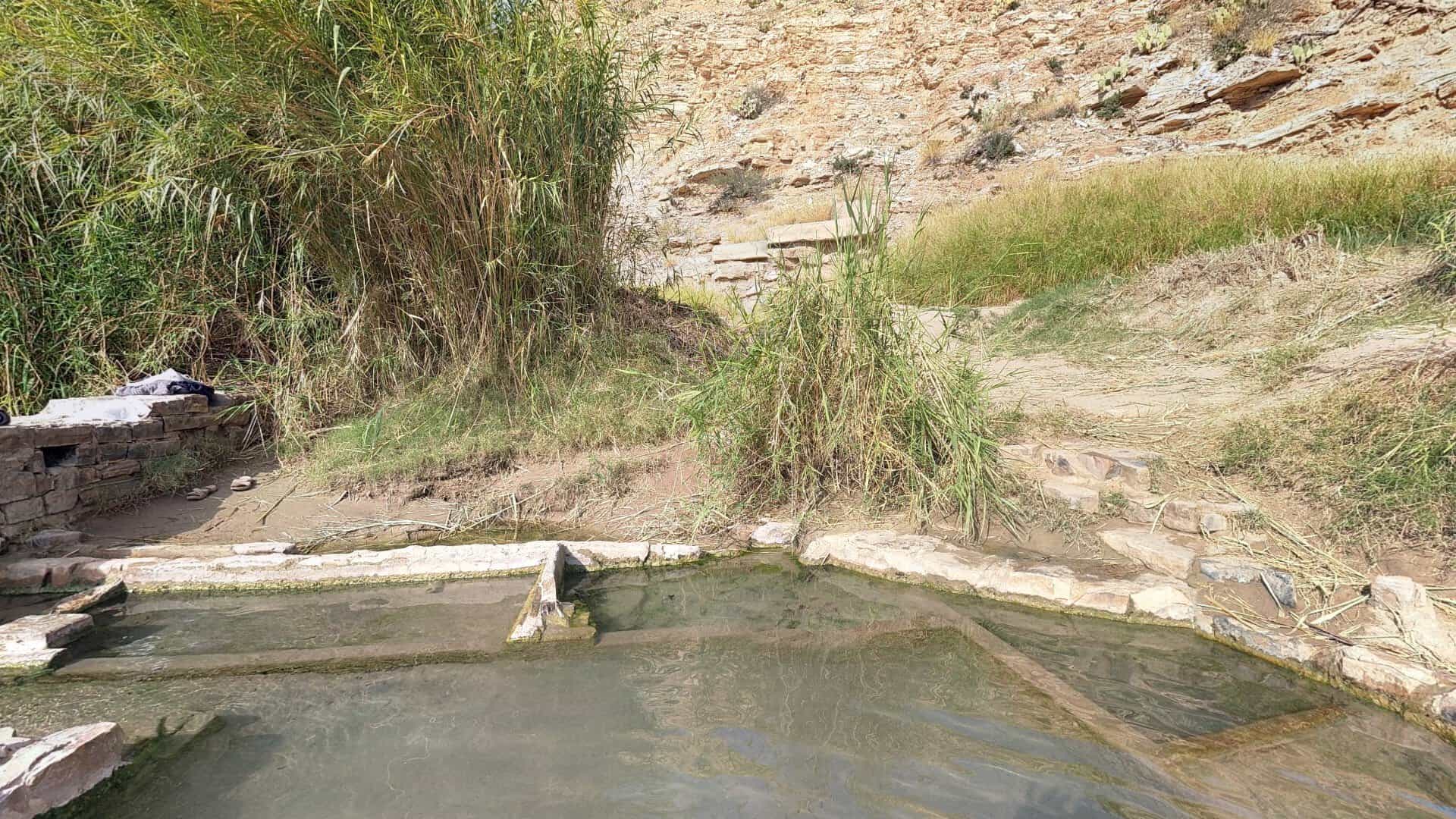 Stone-lined hot spring soaking pool beside the Rio Grande in Big Bend National Park