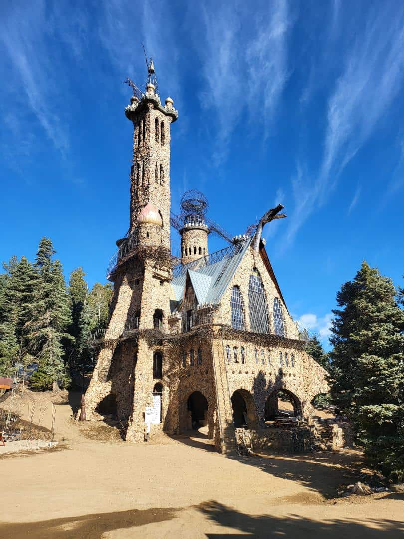 The towering stone and iron Bishop Castle against a blue sky in Colorado