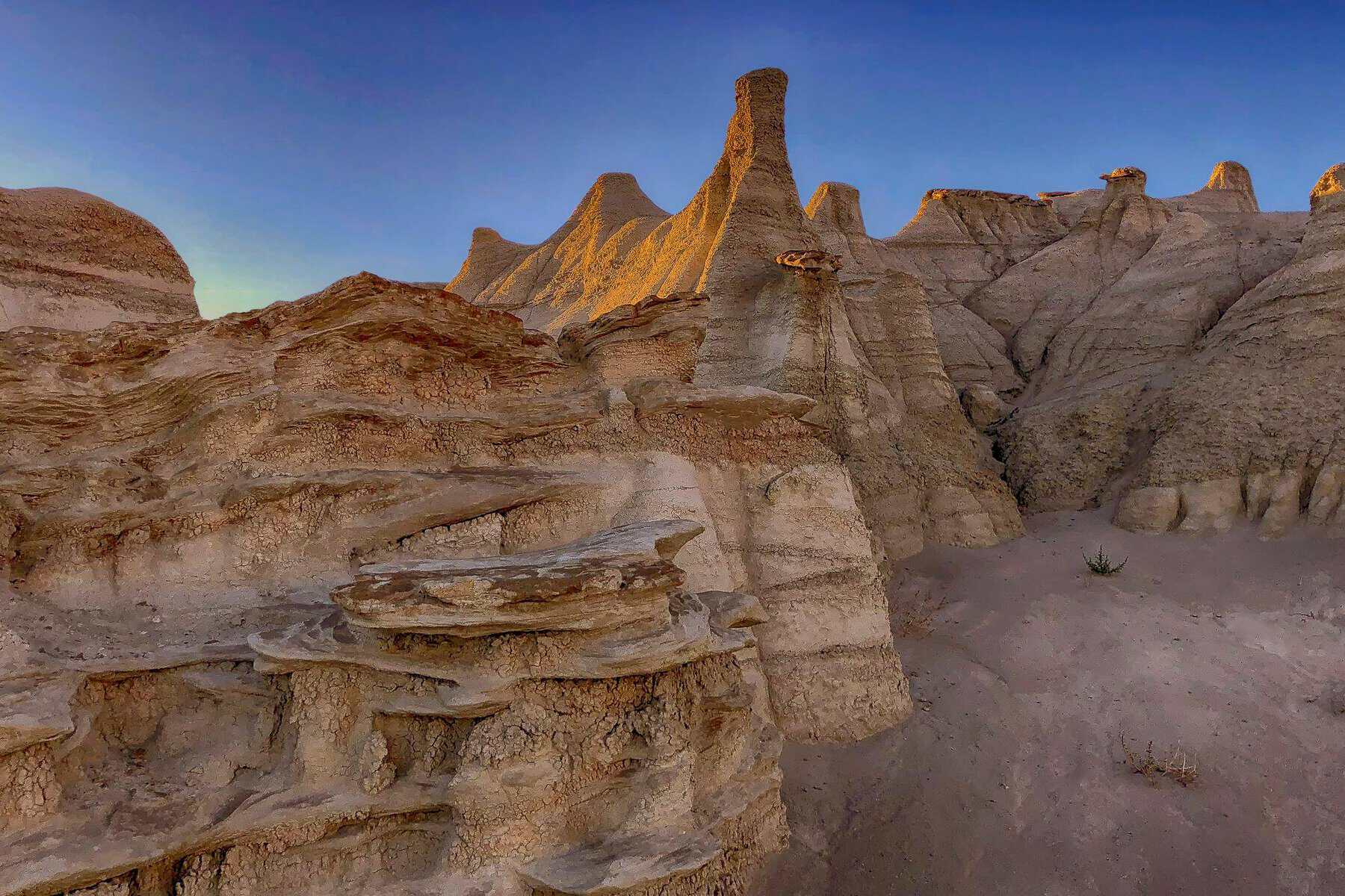 Golden-lit hoodoo rock formations in the Bisti/De-Na-Zin Badlands, New Mexico