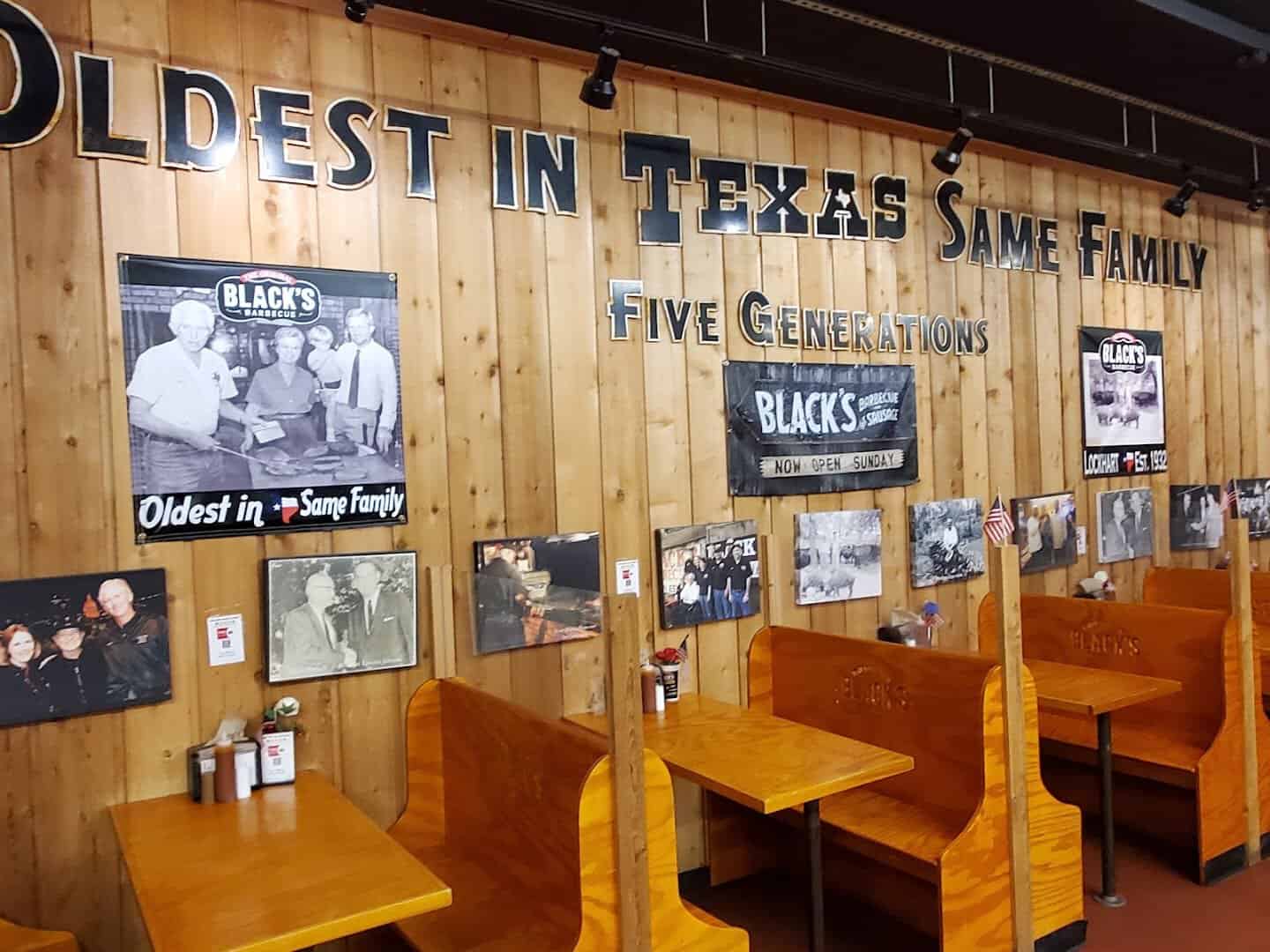 Wall of historic family photos reading Oldest in Texas Same Family at Black's Barbecue in Lockhart