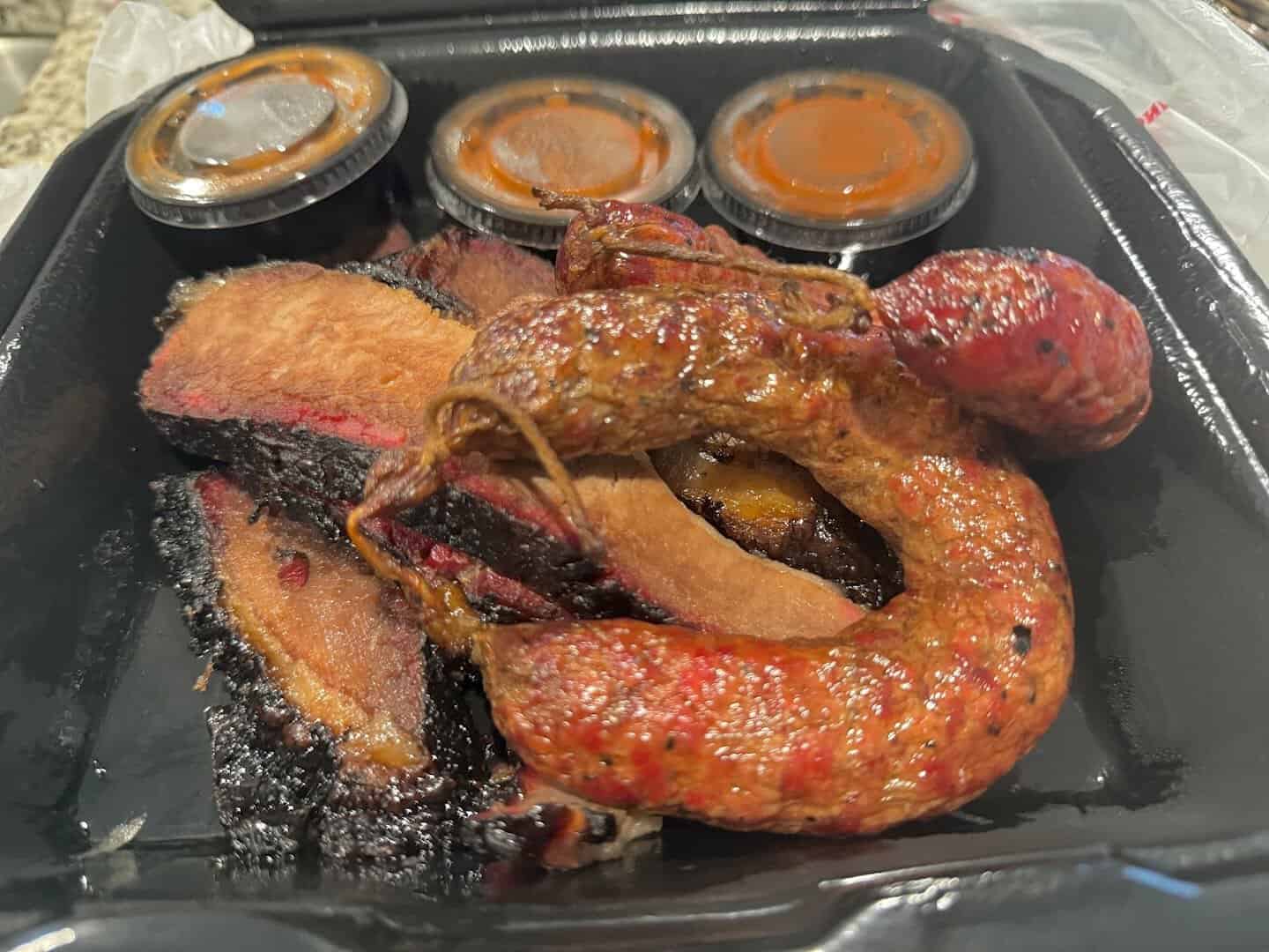 Smoked sausage links with sauce at Black's Barbecue in Lockhart, Texas