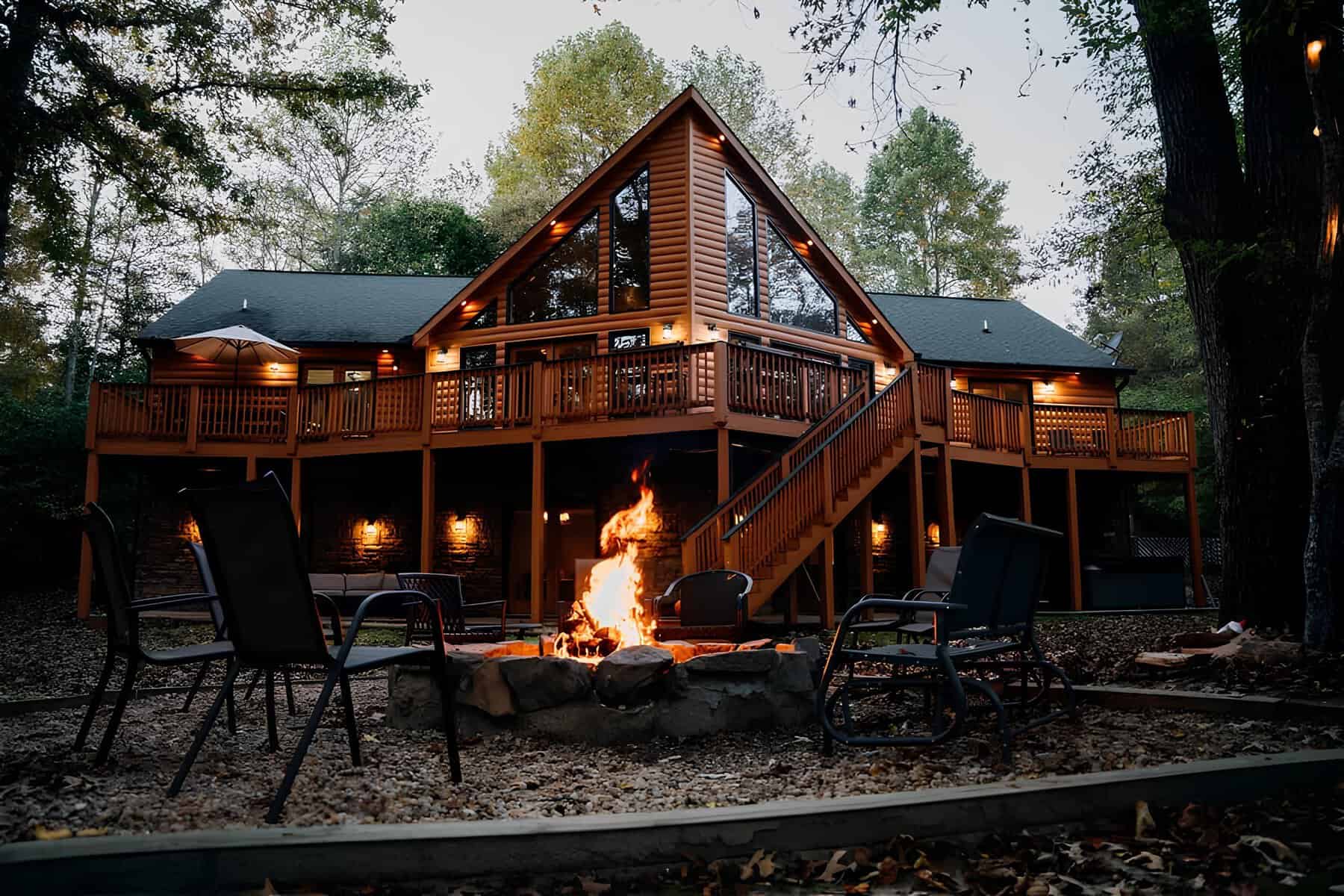 Log cabin glowing at dusk with a fire pit at Blue Creek Cabins near Helen, Georgia