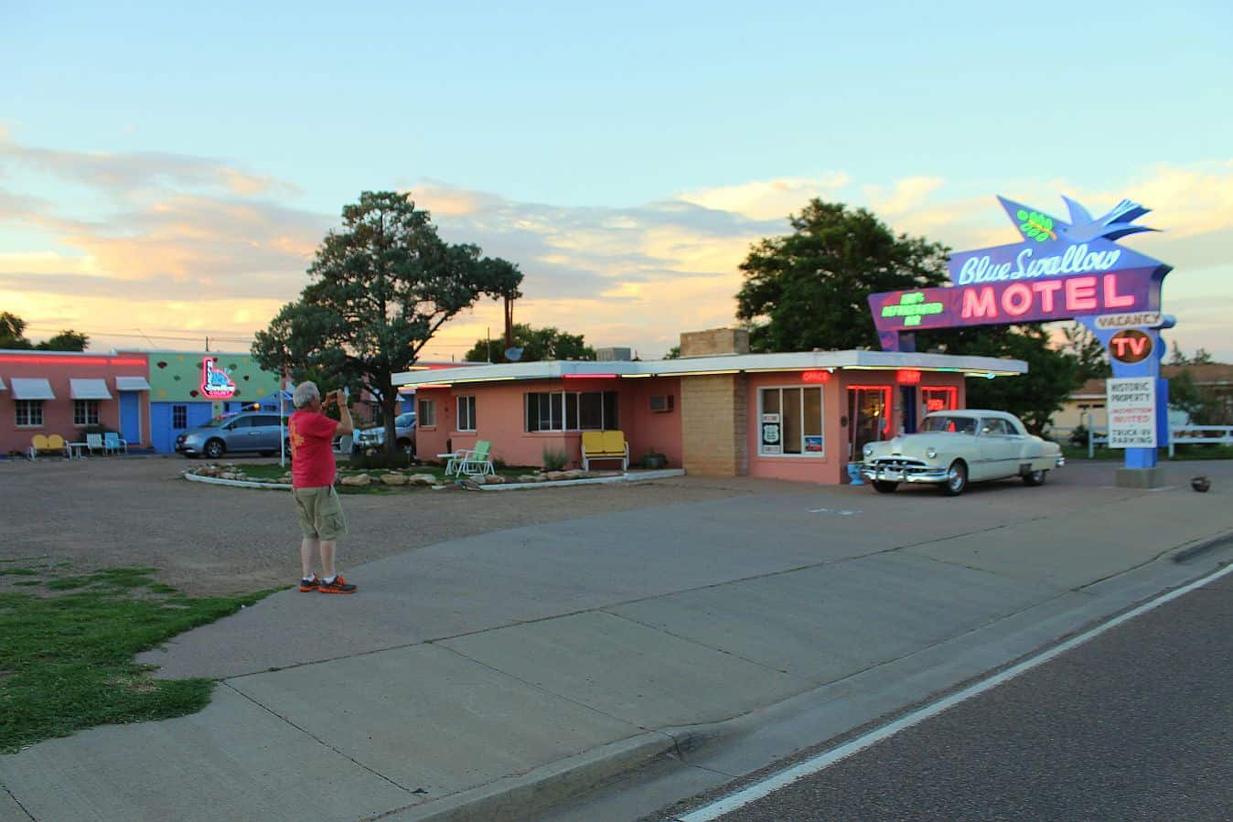 Blue Swallow Motel neon sign and vintage car at dusk in Tucumcari, New Mexico