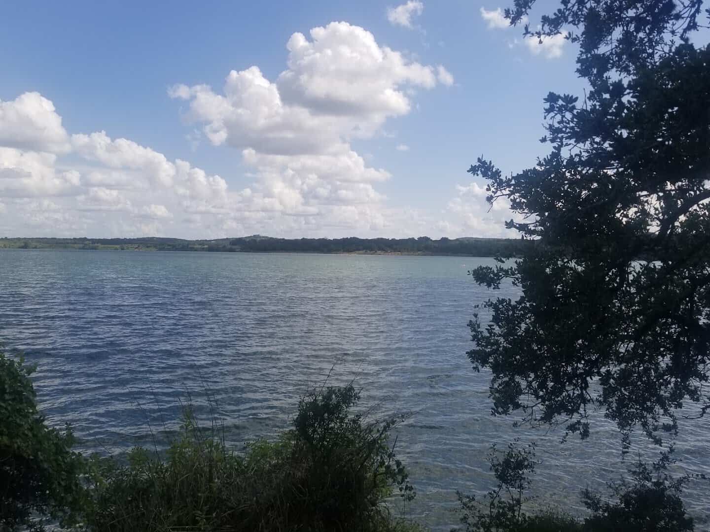 Turquoise water at Boerne City Lake framed by green Hill Country trees in Boerne, Texas