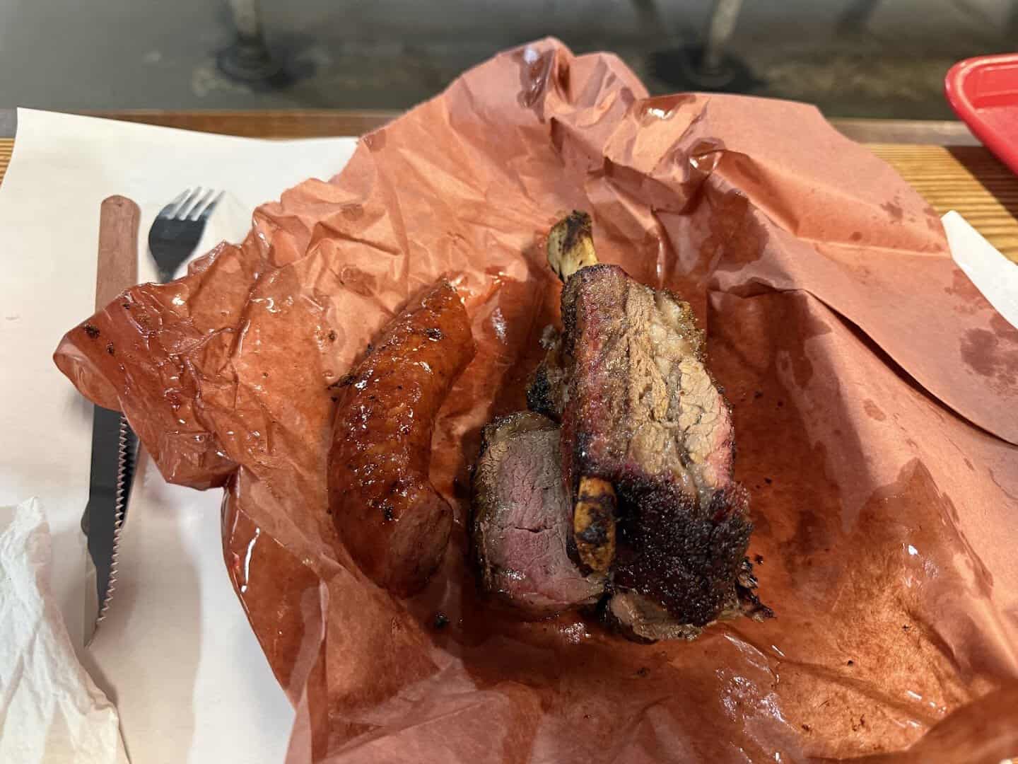 Sliced brisket, sausage and pork chop on butcher paper at Cooper's in Fort Worth