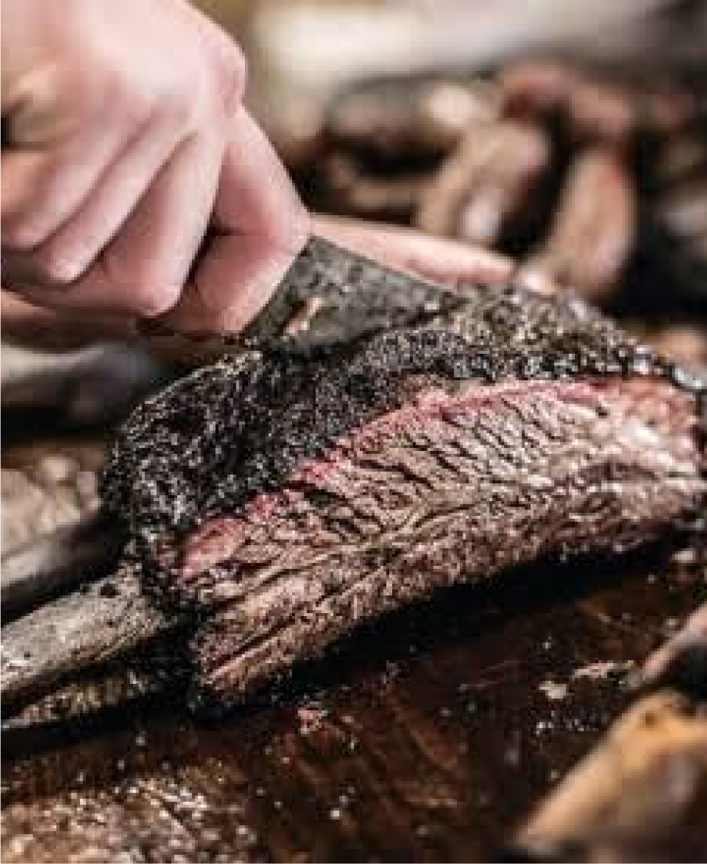 Smoked brisket pulled apart to show the bark and pink smoke ring at Pecan Lodge in Dallas