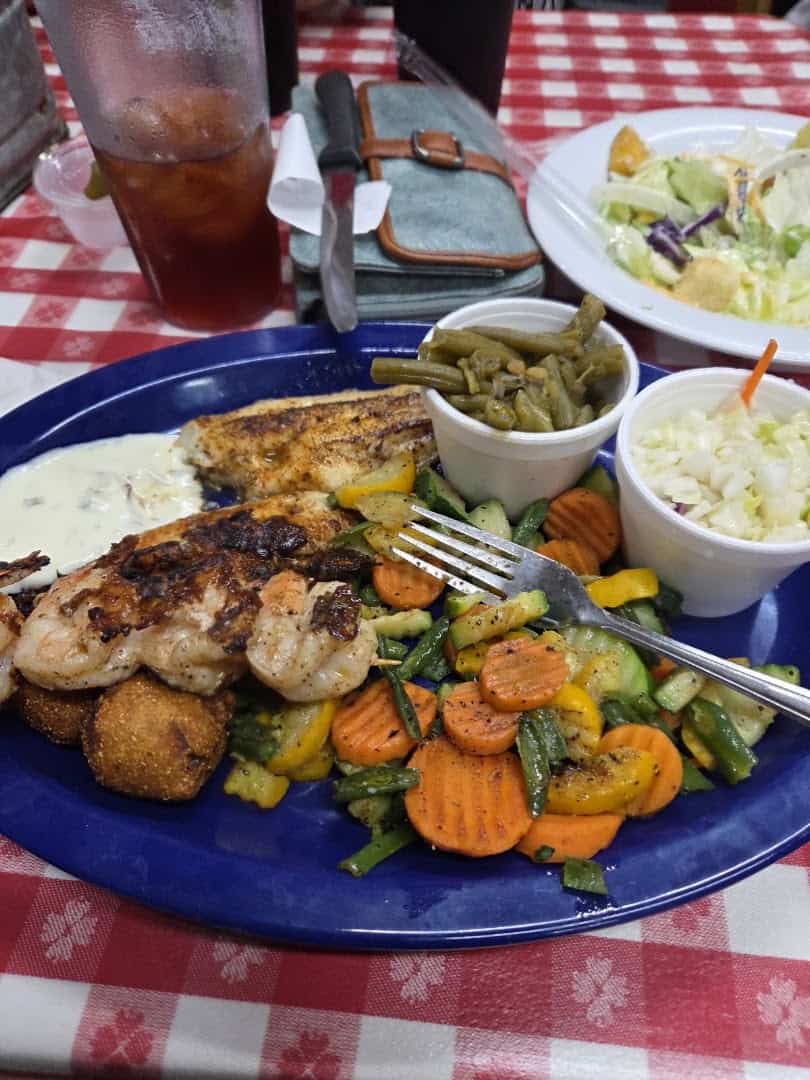 Broiled catfish fillet with sauteed vegetables, green beans, and hush puppies at the Farm House in Mexia, Texas