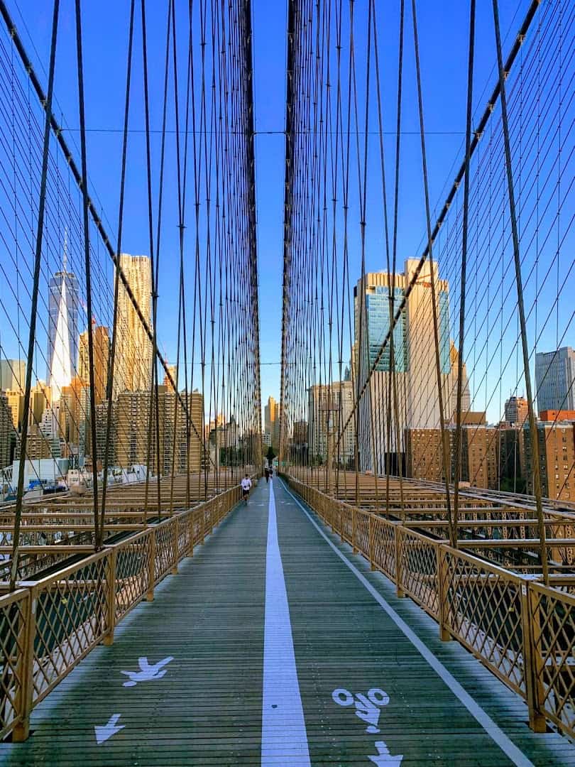 The Brooklyn Bridge walkway leading toward the Manhattan skyline in New York City, New York