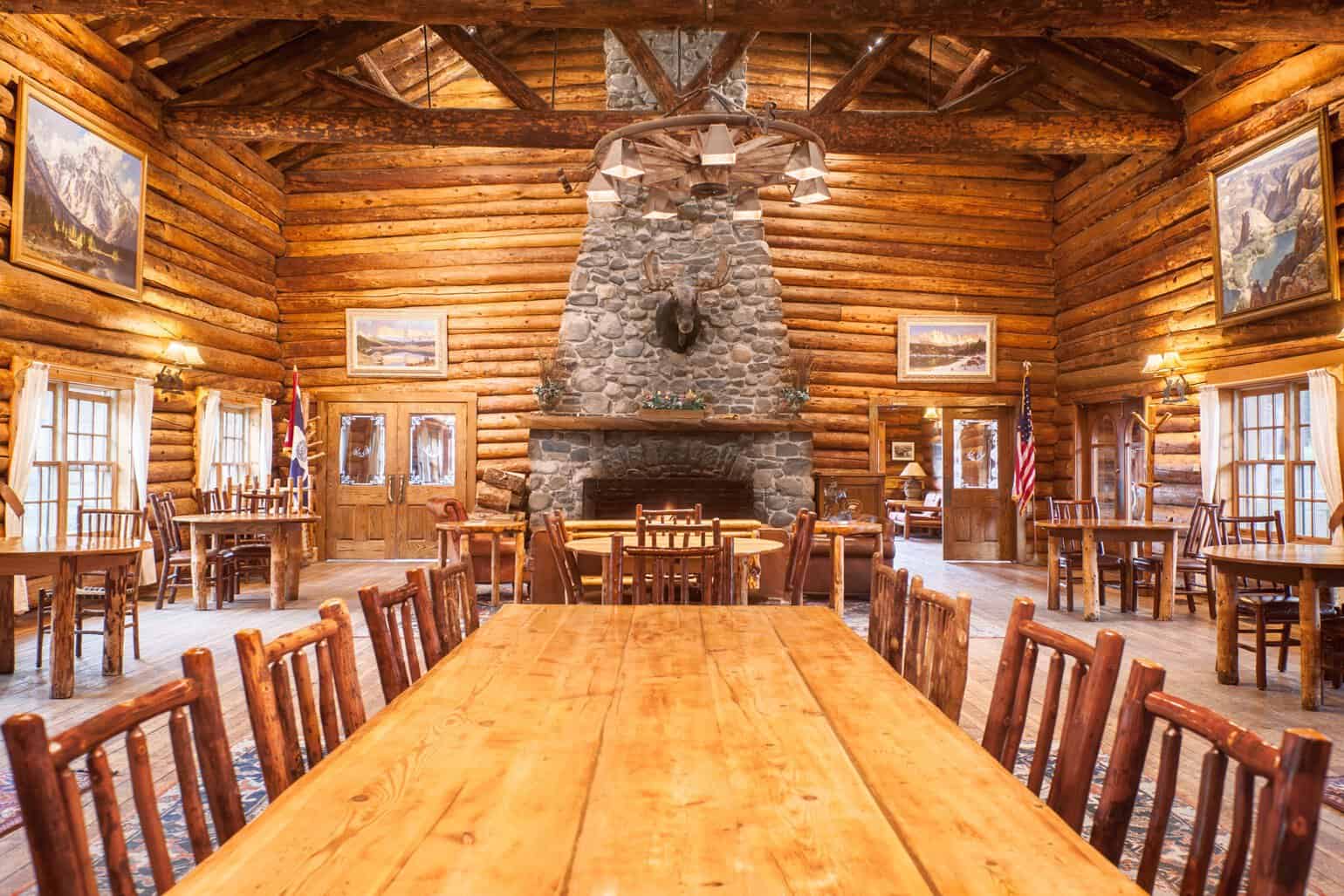 Historic log great room with a stone fireplace at Brooks Lake Lodge in Dubois, Wyoming