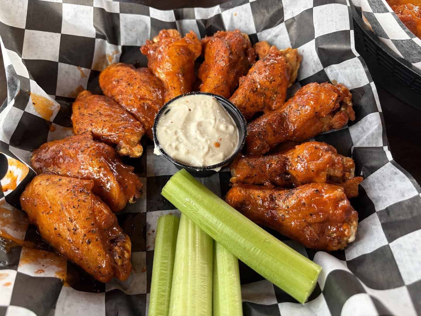Basket of Buffalo chicken wings with celery and blue cheese in western New York