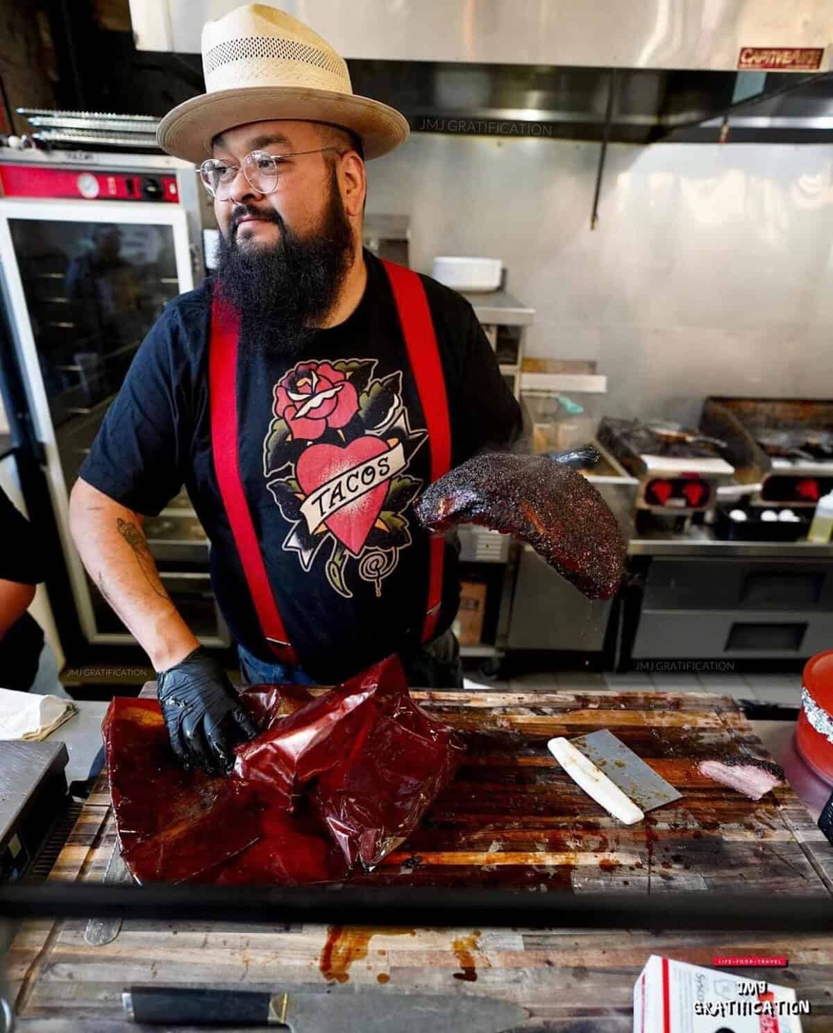 Pitmaster slicing smoked brisket at Burnt Bean Co in Seguin, Texas