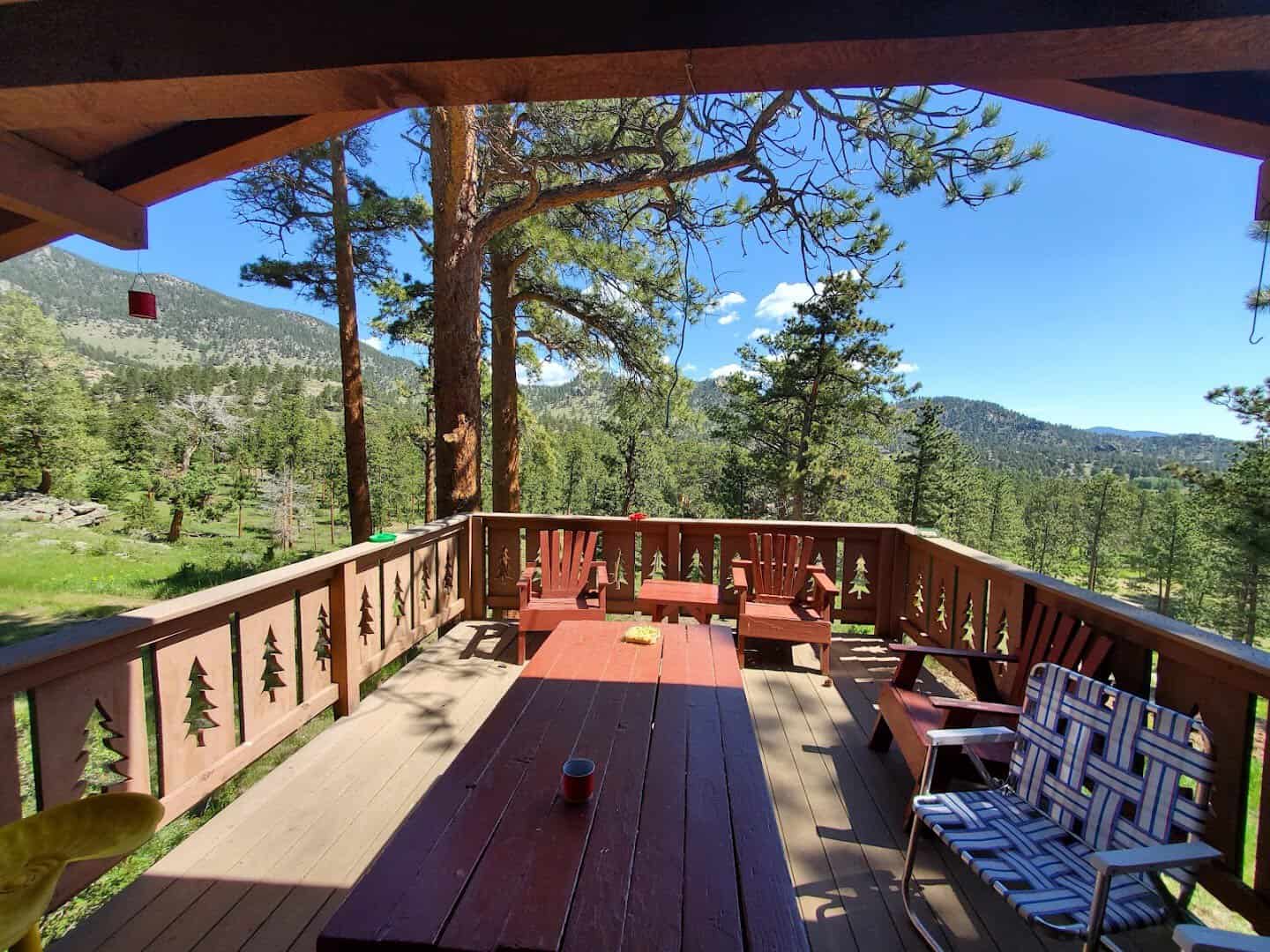 Cabin deck overlooking the Rocky Mountains and pines at Machin's Cottages in the Pines in Estes Park, Colorado