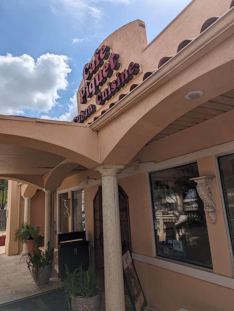 The mission-style building and sign of Cafe Piquet in Bellaire, Texas